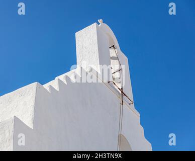 Roof of whitewashed chapel at Kythnos island Chora village Cyclades religious destination Greece. Belfry with old bell chain at Greek Orthodox Christi Stock Photo