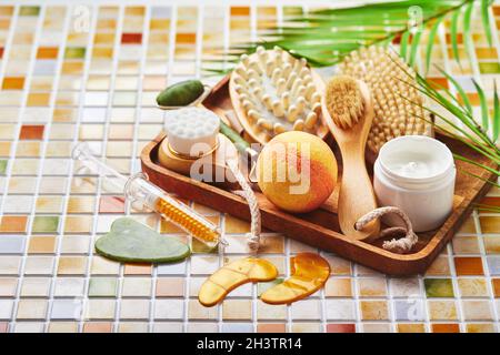 Jars of cream for face and body care, gold eye patches and serum with gold, jade roller massager gau-sha and massager and body b Stock Photo