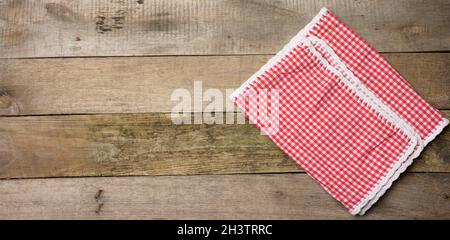 Folded red and white cotton kitchen napkin on a wooden gray background Stock Photo