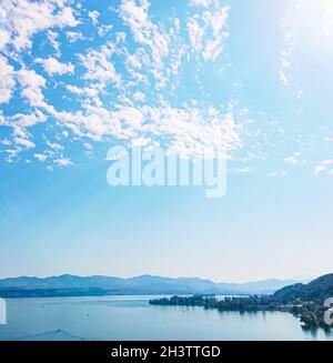 Idyllic Swiss landscape, view of lake Zurich in Wollerau, canton of Schwyz in Switzerland, Zurichsee, mountains, blue water, sky Stock Photo