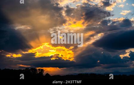 Dramatic sunset sky, light from heaven. Cumulus stormy clouds in summer Stock Photo