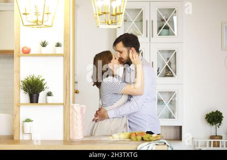 Happy couple cooking and embracing in kitchen Stock Photo