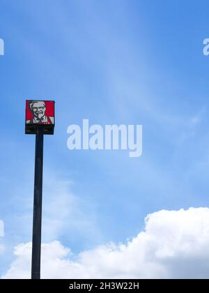 Bangkok, Thailand – June 23, 2021 : KFC logo on pole sign in blue sky background. Kentucky Fried Chicken is a global fast food restaurant chain sellin Stock Photo
