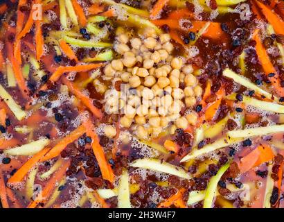 Rice pilaf in a large cast-iron cauldron on fire Stock Photo