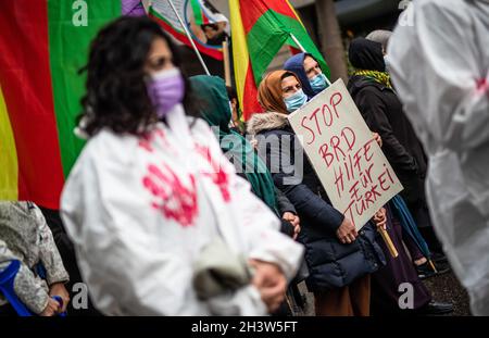 Stuttgart, Germany. 30th Oct, 2021. Supporters of the Kurds walk through downtown Stuttgart during a demonstration. A woman carries a poster with the inscription 'Stop FRG aid to Turkey'. They are demonstrating against the Turkish military deployment in northern Iraq. Credit: Christoph Schmidt/dpa/Alamy Live News Stock Photo