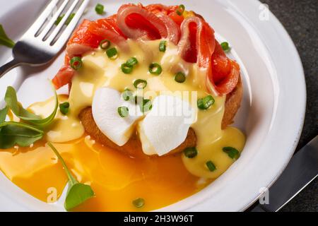 Eggs Benedict with salmon and hollandaise sauce on plate Stock Photo