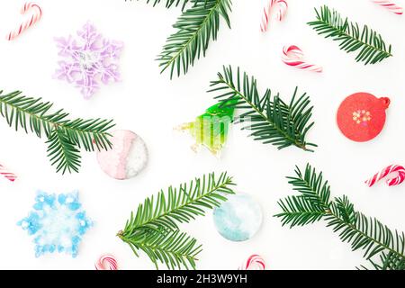 Christmas frame with toys, candy canes and evergreen tree branches on white. Flat lay Stock Photo
