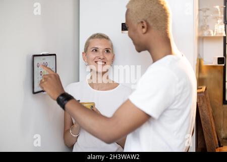 Young couple controlling smart home devices on a digital tablet Stock Photo