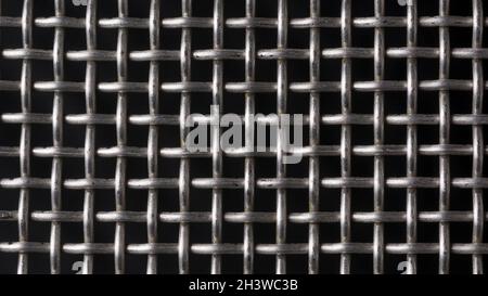 metal protective grille isolated on black, geometric background texture for designing, seamless pattern of wire fence or net structure closeup view Stock Photo
