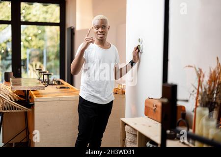 Latin man choosing temperature on thermostat Stock Photo