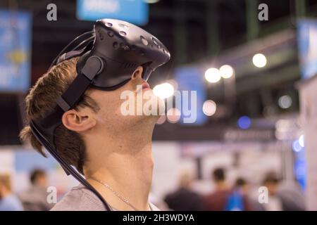 Young man wearing virtual reality glasses on an expo is having fun Stock Photo