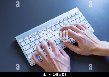 Typing fingers on a white keyboard, online business Stock Photo