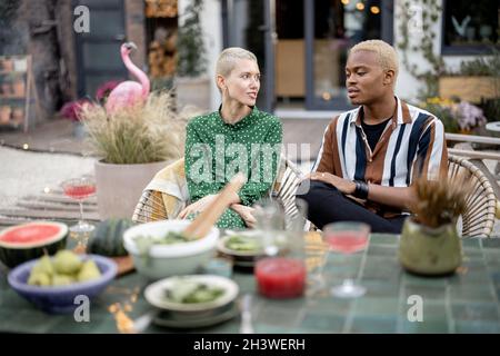 Multiracial couple having dinner at their backyard Stock Photo