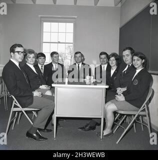 1968, historical, a group of male and female members of the student council of Monroe College, a private business college in Middletown, Virginia, USA, in a room sitting in their college blazers around a table. Stock Photo