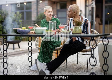 Multiracial couple having dinner at their backyard Stock Photo
