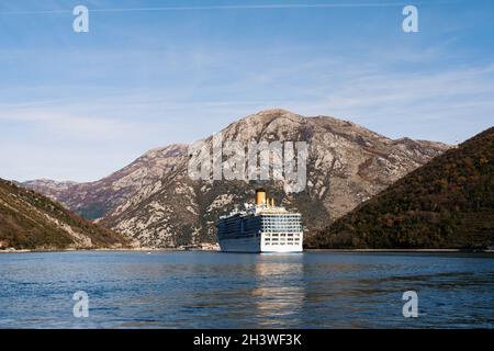 A tall, high-rise huge cruise liner in the Verige Strait, in the Boka Kottorska - Kotor Bay in Montenegro, against the backdrop Stock Photo