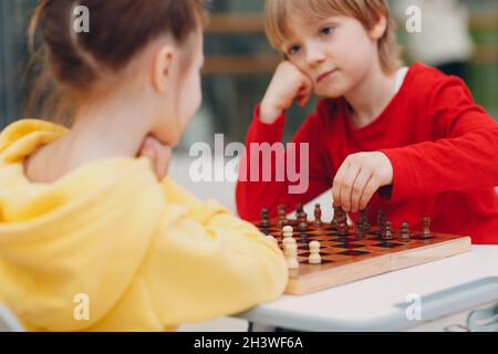 Little kids playing chess at kindergarten or elementary school Stock Photo