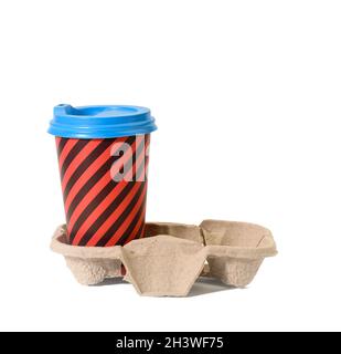 Paper red striped disposable cup with plastic lid stands in paper holder on white isolated background Stock Photo