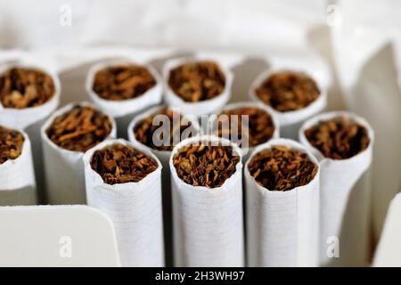 A pack of cigarettes is open and there are several cigarettes without filter  Stock Photo