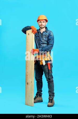 Full length portrait of young handsome carpenter hold pile of lumber woods Stock Photo