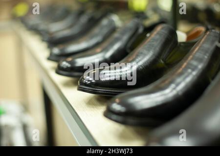 Black shoes in the store. Shoes are in a row. Lacquered shoes on sale. Lots of shoes. Stock Photo