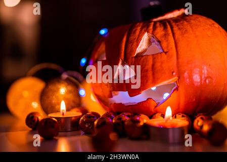 Spooky smiling halloween pumpkin in burning fire candles flames. Stock Photo