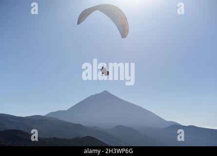 Paraglider flying in the blue sky with Mount Teide at the background. Tenerife, Canary Islands, Spain. Stock Photo