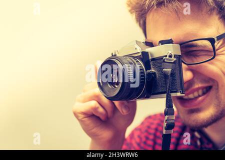 Young man is taking a picture with a vintage camera Stock Photo