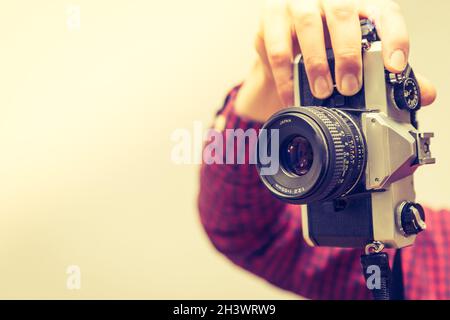 Young man is taking a picture with a vintage camera Stock Photo
