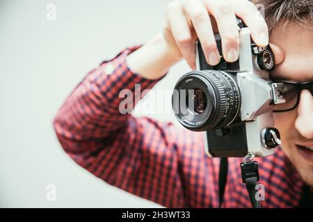 Young man is taking a picture with a vintage camera Stock Photo