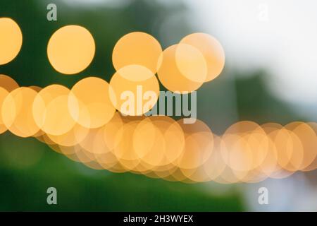 Yellow bokeh on a green background. Blurred background. Yellow circles of a defocused lens Stock Photo