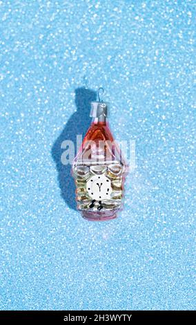 Clock Christmas glass Christmas tree toy on a shiny blue background. Stock Photo