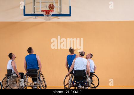 Disabled War veterans mixed race opposing basketball teams in wheelchairs photographed in action while playing an important matc Stock Photo