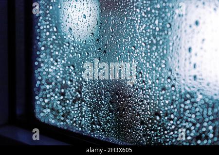Rain drops on the window, rainy night with cool lights. Drop pattern, window frame Stock Photo