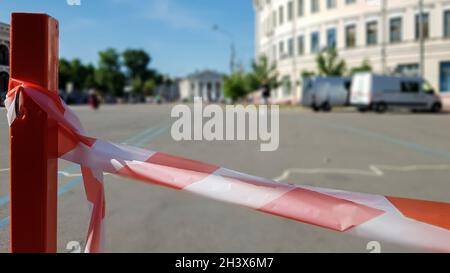 Red white does not cross the tape and the metal pole. Signal red and white tape hanging on a metal fence, danger, warning. Ribbo Stock Photo