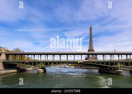Eiffel Tower against blue sky with clouds and a bridge over Seine River. Paris France. April 2019 Stock Photo