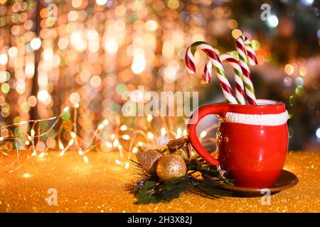 Red cup on a saucer with candy cane. copyspace Stock Photo