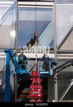 workers doing maintenance on Japan Tobacco International headquarters, designed by Skidmore, Owings & Merrill (SOM), Geneva, Switzerland Stock Photo