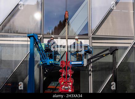 workers doing maintenance on Japan Tobacco International headquarters, designed by Skidmore, Owings & Merrill (SOM), Geneva, Switzerland Stock Photo