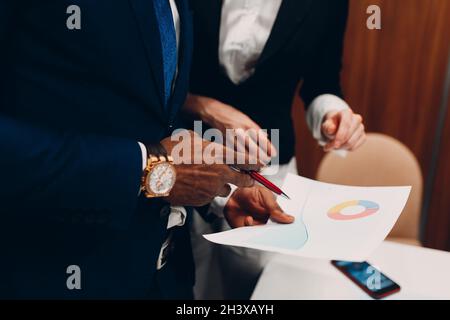 Businessman and businesswoman accountant team showing graph chart at office meeting. Business people group conference discussion Stock Photo