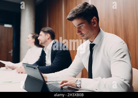 Businessman using working with laptop sits at table at office meeting. Business people man and woman group conference discussion Stock Photo