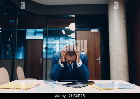 Sad african american black Businessman sit at office table. Business people in crisis and depression after covid-19 pandemia con Stock Photo