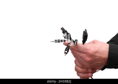In the hands of a man, a bunch of different cables of computer connectors. copy space Stock Photo