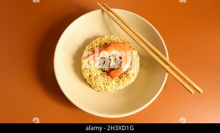 Spicy instant noodle soup with shrimp. shrimp soup, cooking, food. Raw dried circle-shaped vermicelli in a plate. Asian food. pa Stock Photo