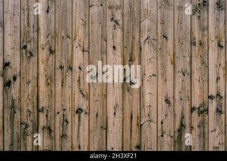 The texture of dark wooden planks knocked down in an upright position of brown color close-up. Stock Photo