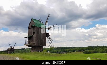 Ukraine, Kiev - June 11, 2020. Old Ukrainian wooden windmills of the XIX century. Summer outdoor landscape. Open-air museum of f Stock Photo