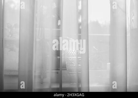 Real charming light transparent curtains on window at grey morning Stock Photo