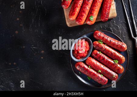 Grilled sausages, shot from above on a dark background with copy space Stock Photo