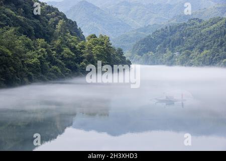 Cast fishing net on the foggy river Stock Photo