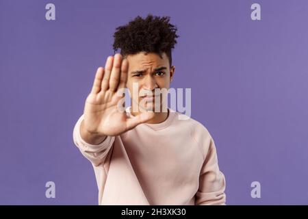 Man you should stop. Close-up portrait of young serious-looking male friend trying to warn person of doing something bad, raise Stock Photo